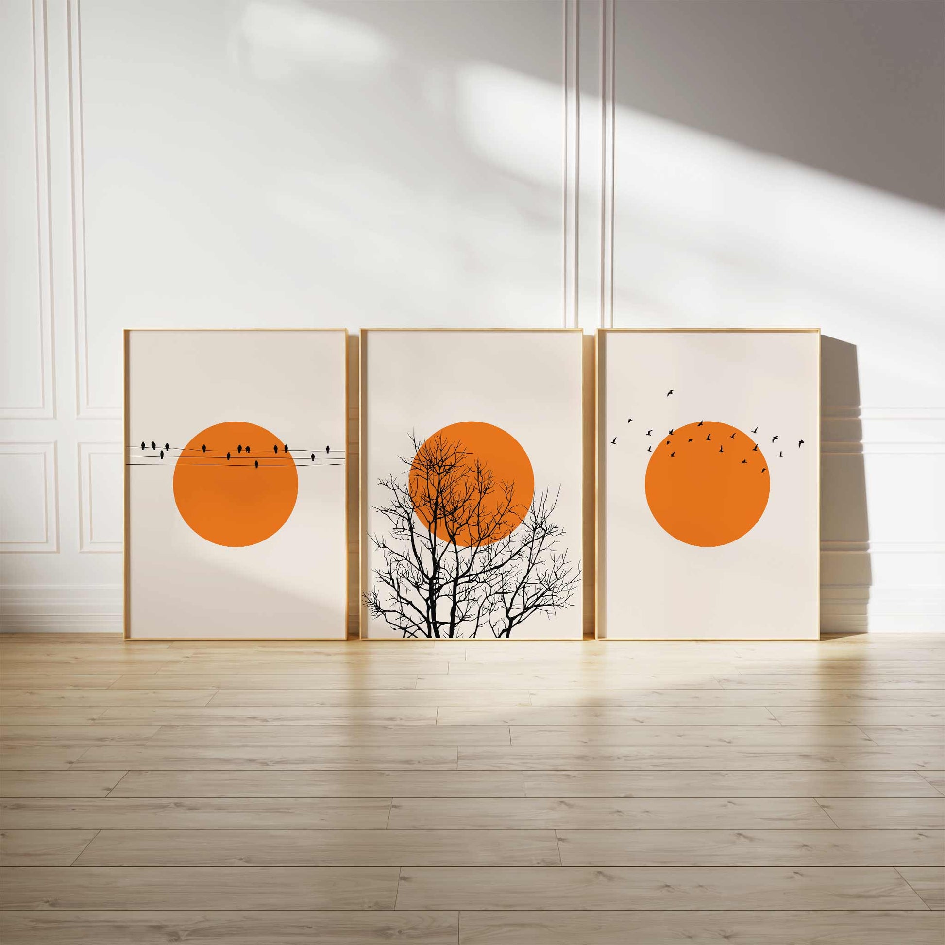 Minimalist sunset art print set featuring three orange sun designs with birds and trees, perfect for nature-inspired modern decor.